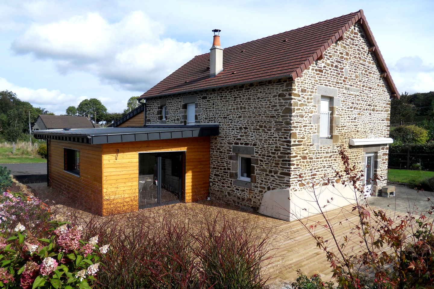 Maison de campagne rénovée par chaury-tp près de Toulouse, mariage pierre et extension bois avec jardin paysager
