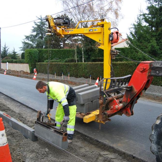 Ouvrier chaury-tp posant des bordures de trottoir avec grue sur chantier routier à Toulouse